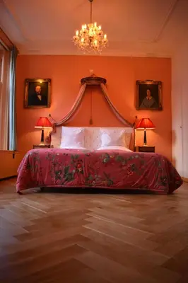 a bedroom with a red bed with two lamps at Boutique Hotel Museumkwartier in Utrecht