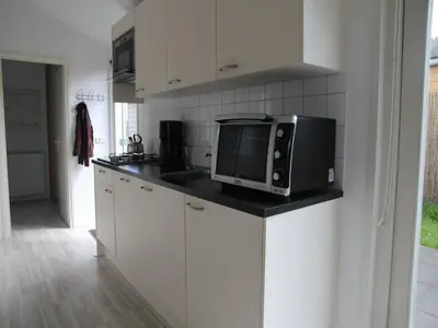 a kitchen with a microwave on top of a counter at Pet-Friendly Bungalow in Warmenhuizen