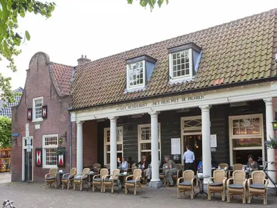 a group of people sitting outside of a building at Pet-Friendly Bungalow in Warmenhuizen