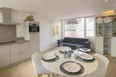 a kitchen and dining room with a white table and chairs at Studio Noordwijk in Noordwijk