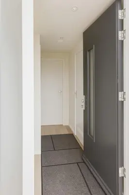 a hallway with a gray door and a hallway with at Studio Noordwijk in Noordwijk