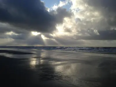 a beach with a cloudy sky and the ocean at Marinus, lovely bungalow near the sea and most beautiful dune area in the Netherlands in Warmenhuizen