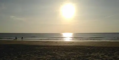 two people walking on the beach at sunset at Marinus, lovely bungalow near the sea and most beautiful dune area in the Netherlands in Warmenhuizen