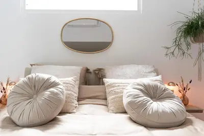 a bedroom with a bed with pillows and a mirror at Ben Thuis Studio Alkmaar in Alkmaar