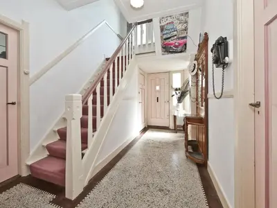 a hallway with a white staircase with pink carpet at Characteristic country house with wellness