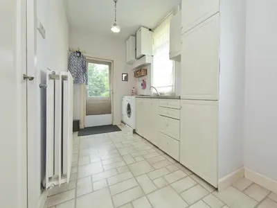 a kitchen with white cabinets and a tile floor at Characteristic country house with wellness