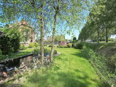 a park with a pond and trees and a house at Characteristic country house with wellness