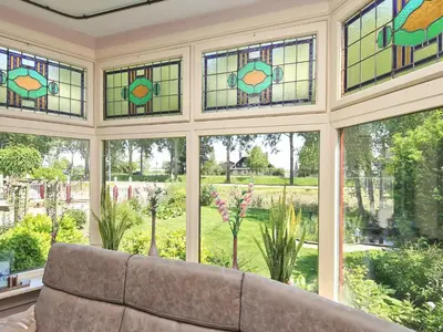 a conservatory with stained glass windows and a couch at Characteristic country house with wellness