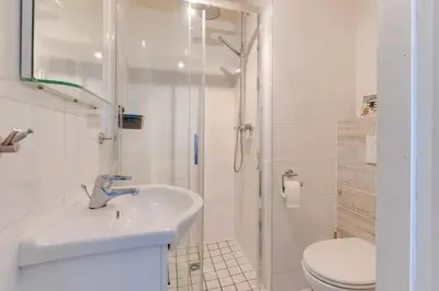 a bathroom with a shower and a sink and a toilet at Duynhof nabij Strand, duinen, bos en stad - 5 personen in Warmenhuizen