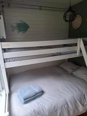 a bunk bed with a towel on top of it at Duynhof nabij Strand, duinen, bos en stad - 5 personen in Warmenhuizen