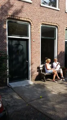 two women sitting on a bench in front of a building at Park 43 in Haarlem