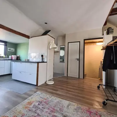 a large kitchen with white cabinets and a table at Park 43 in Haarlem