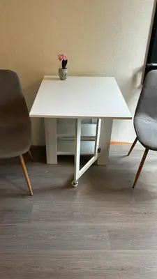 a white table with a vase with a flower on it at Vlinder 2pers studio in Utrecht