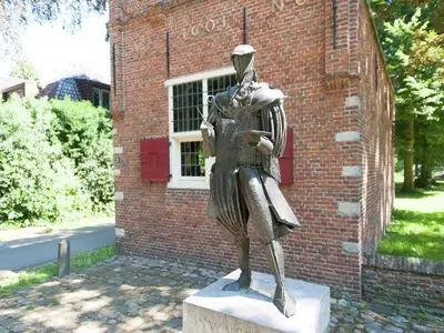 a statue of a woman standing in front of a brick building at Holiday Home in Schoorl near Dunes in Schoorl