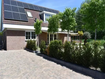 a house with solar panels on the roof at Villa in Bosrijk near Horsterwold Forest in Zeewolde