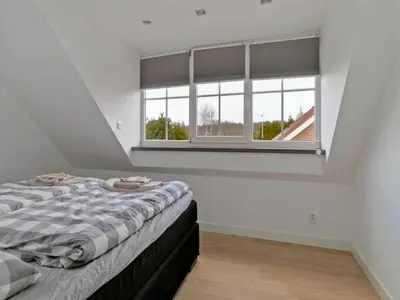 a bedroom with a bed and a large window at Villa in Bosrijk near Horsterwold Forest in Zeewolde