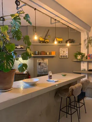 a kitchen with a counter with stools and a plant at B&B Loft 57 in Amsterdam