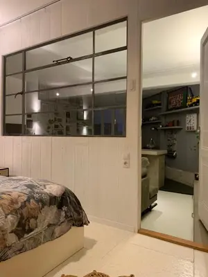 a bedroom with a bed and a large window at B&B Loft 57 in Amsterdam