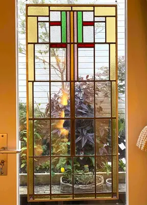 a stained glass window with a view of a garden at B&B Loft 57 in Amsterdam