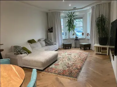 a living room with a white couch and a rug at Luxury apartment in the pijp near the Rai in Amsterdam
