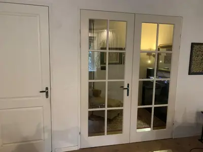 a white cabinet with glass doors in a room at Luxury apartment in the pijp near the Rai in Amsterdam