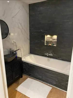 a bathroom with a black and white tub and a sink at Luxury apartment in the pijp near the Rai in Amsterdam