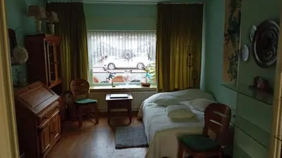 a bedroom with a bed and a window with a car at classic beach home in Zandvoort
