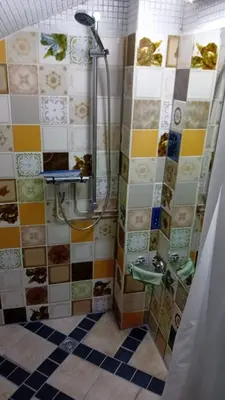 a bathroom with a shower with colorful tiles at classic beach home in Zandvoort
