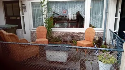 a porch with two chairs and a window at classic beach home in Zandvoort