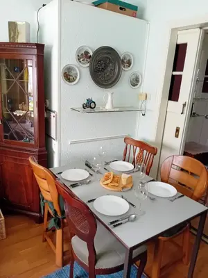a dining room with a table with plates on it at classic beach home in Zandvoort