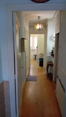a hallway leading to a room with a kitchen and a door at classic beach home in Zandvoort