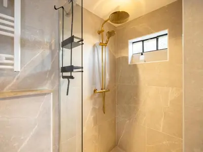 a shower with a glass door in a bathroom at Rekerlanden 1 in Warmenhuizen