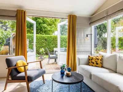 a living room with a couch and a table at Het Zonneschijnhuis in Dirkshorn