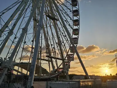 a ferris wheel with the sunset in the background at Sandy beach 34 in Noordwijk