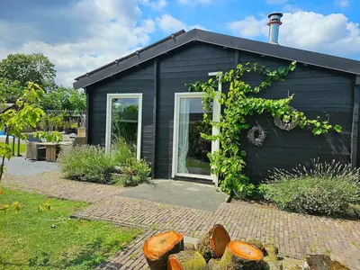 a black house with vines growing on the side of it at De Fijne Blokhut in Nijkerkerveen