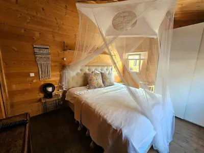 a bedroom with a bed with a mosquito net at De Fijne Blokhut in Nijkerkerveen