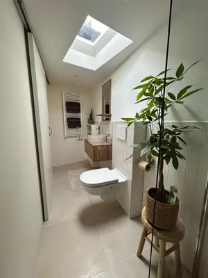 a bathroom with a toilet and a plant in it at Tiny house by the beach in Noordwijk aan Zee