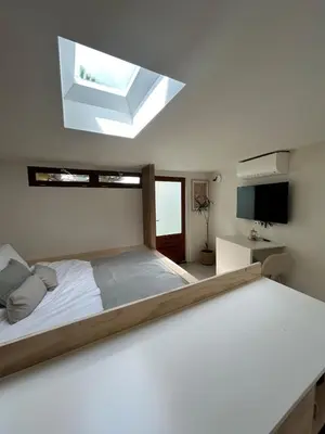 a bedroom with a large bed with a skylight at Tiny house by the beach in Noordwijk aan Zee