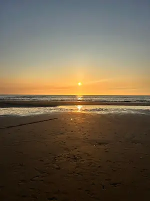 a sunset on a beach with the ocean at Tiny house by the beach in Noordwijk aan Zee