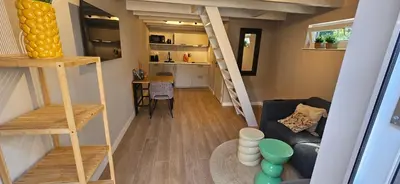 a small living room with stairs and a couch at Bulbs & Beach in Noordwijk
