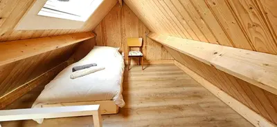 a small room with a bed in a wooden cabin at Bulbs & Beach in Noordwijk