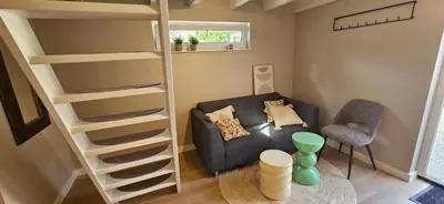 a living room with a couch and a bunk bed at Bulbs & Beach in Noordwijk