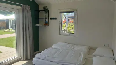 a bed in a room with a window and a window at Recreatie aan de Vecht, Hooibergje 3, Weesp in Weesp