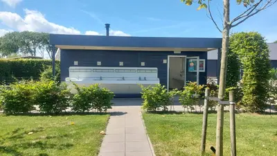 a small blue house with a sidewalk in front of it at Recreatie aan de Vecht, Hooibergje 3, Weesp in Weesp