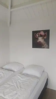 a bed with a picture of a cow on the wall at Recreatie aan de Vecht, Hooibergje 3, Weesp in Weesp