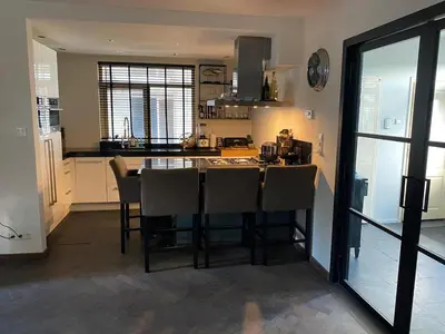 a kitchen with a table and chairs in a room at Ruime woning met jacuzzi, 10 min van strand in Lisse