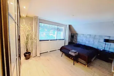 a bedroom with a bed and a large window at Ruime woning met jacuzzi, 10 min van strand in Lisse
