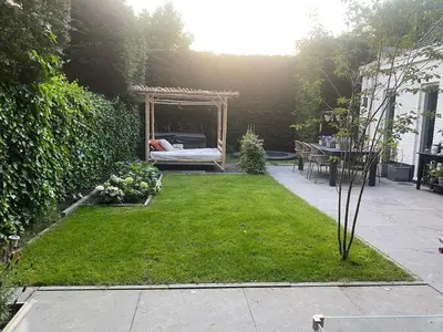 a garden with a bed and a gazebo at Ruime woning met jacuzzi, 10 min van strand in Lisse