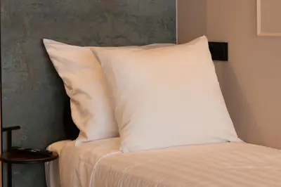 a white pillow sitting on top of a bed at Midtown Hotel triple in Amsterdam