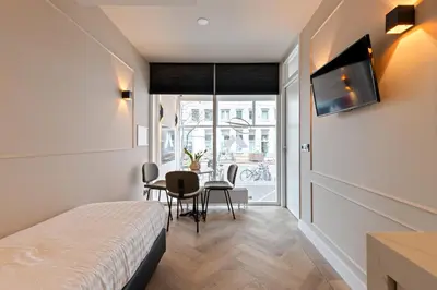 a room with a bed and a table with chairs at Midtown Hotel triple in Amsterdam
